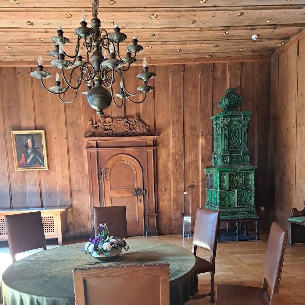 A wood-paneled dining room with a green tiled stove.